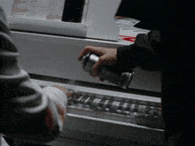 a person is spraying a can of spray paint on a piano