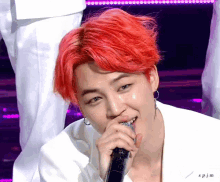 a man with red hair is singing into a microphone with the name spjm below him