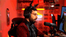 a man wearing headphones and bunny ears is sitting in front of a computer