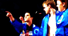 a man in a blue jacket with the letter c on it is pointing