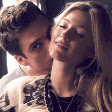 a man is kissing a woman on the neck while she smiles