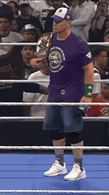 a wrestler wearing a purple shirt that says " best time is now " on it