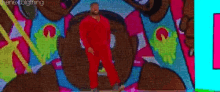a man in a red suit is standing in front of a colorful wall with the words " the next big thing " on it