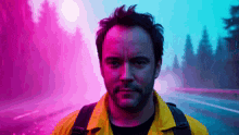 a man in a yellow jacket is standing in front of a purple and blue background