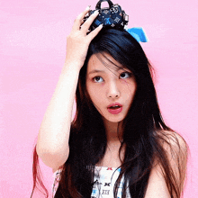 a woman holding a small louis vuitton purse on her head