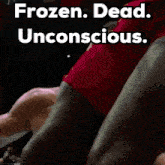 a shirtless man is laying on the ground in a boxing ring with the words frozen dead unconscious .