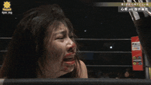 a woman with blood on her face is standing in a wrestling ring with the hashtag #pw_mg on the bottom