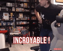 a man in a black shirt is standing in front of a bookshelf with the words incroyable written on it