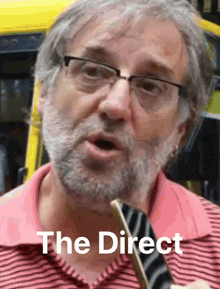 a man with glasses and a beard is talking into a microphone and the words the direct are visible