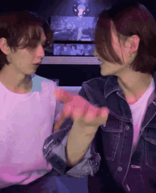 a man and a woman are sitting next to each other and the woman is wearing a denim jacket