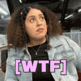 a woman in a denim jacket says wtf in pink