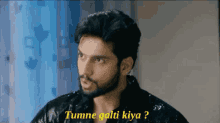 a man with a beard and a black jacket says tumne galti kiya