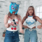 a woman wearing a mask is dancing next to another woman wearing a tank top that says tokyo tide