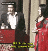 a man in a tuxedo stands next to a woman in a red dress and says srk : in this room