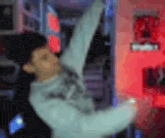 a blurry picture of a man standing in front of a red light .
