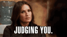a woman is sitting in front of a water cooler and says `` judging you . ''