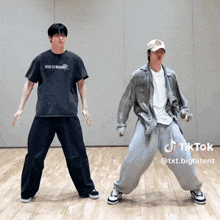 a man in a deus ex machina t-shirt is dancing with another man