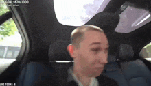 a man is sitting in the back seat of a car with a score of 870/1000
