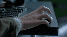 a close up of a person typing on a keyboard with the bbc logo visible