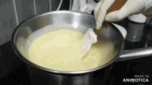 a person is stirring a pot of liquid with a spatula and the words made in animotica on the bottom