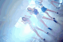 a group of women are dancing in a room with blue lights