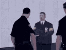 a man with a fbi patch on his sleeve talks to another man