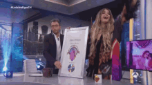 a man and a woman are holding a framed picture that says lola indigo