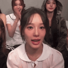 a girl in a white shirt with a white collar looks at the camera with her mouth open