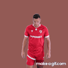 a man wearing a red superbet jersey dancing