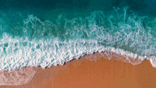 an aerial view of a beach with waves crashing on it