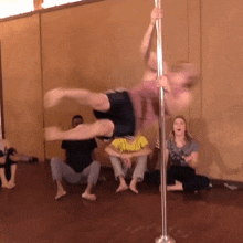 a group of people sit on the floor watching a pole dancer