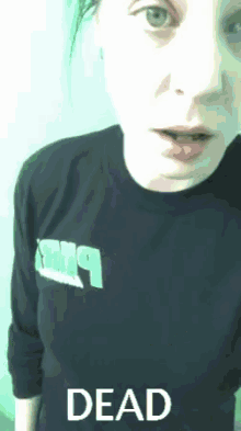 a woman is wearing a black shirt with the word dead on it