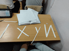 a wooden desk with a stack of papers on top of it and the letters x and y cut out of paper