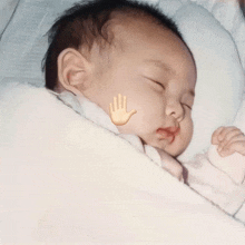 a baby is sleeping with a hand drawn on his face