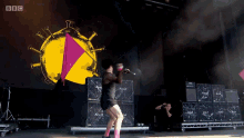a woman is dancing on a stage with a bbc logo behind her