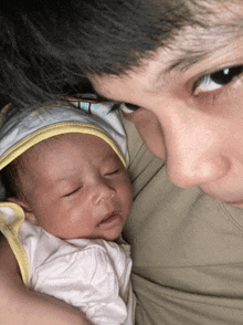 a man holds a baby in his arms and looks at it
