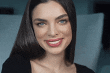 a close up of a woman 's face with blue eyes and red lips
