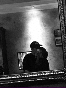 a man is taking a picture of a woman in a mirror