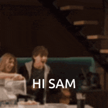 a blurry picture of a person sitting at a table with the words hi sam written on the bottom