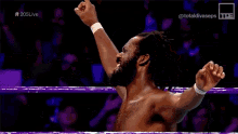 a man without a shirt is wrestling in a ring with a woman watching .
