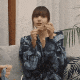 a woman is sitting on a couch holding a piece of paper