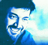 a man with a beard is smiling in a blue and white photo