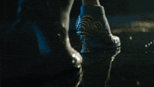 a woman 's feet are standing in a puddle of water with a heart shaped heel