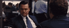 a man in a suit and tie sits at a table