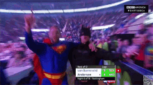 a man in a superman costume is standing next to another man