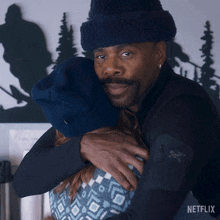 a man wearing a black jacket with a skull and crossbones on the sleeve is hugging a woman