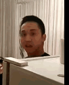 a man is standing in front of a white refrigerator .