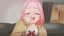 a girl with pink hair is yawning with her hand on her face