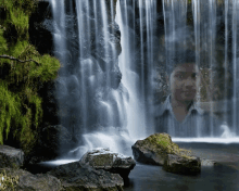 a man stands in front of a waterfall with a picture of him in the background
