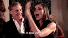 a man and a woman are standing next to each other and the woman is yelling .